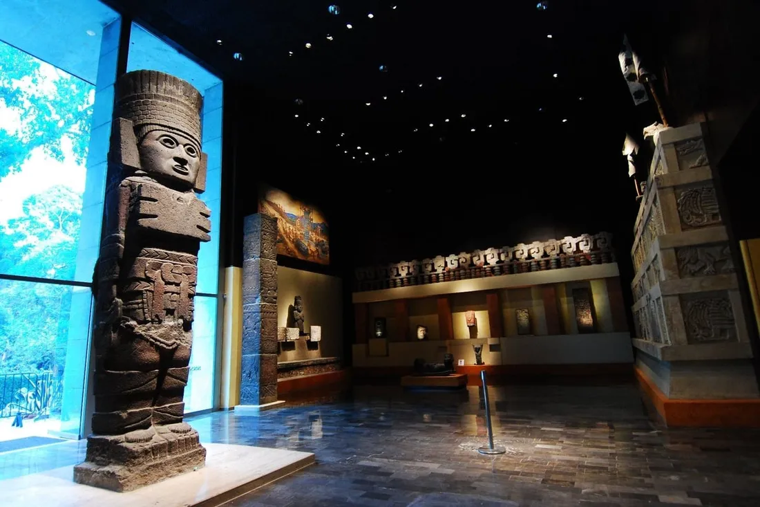 Visitors on an anthropology museum private tour standing beneath the Aztec Sun Stone in Mexico City